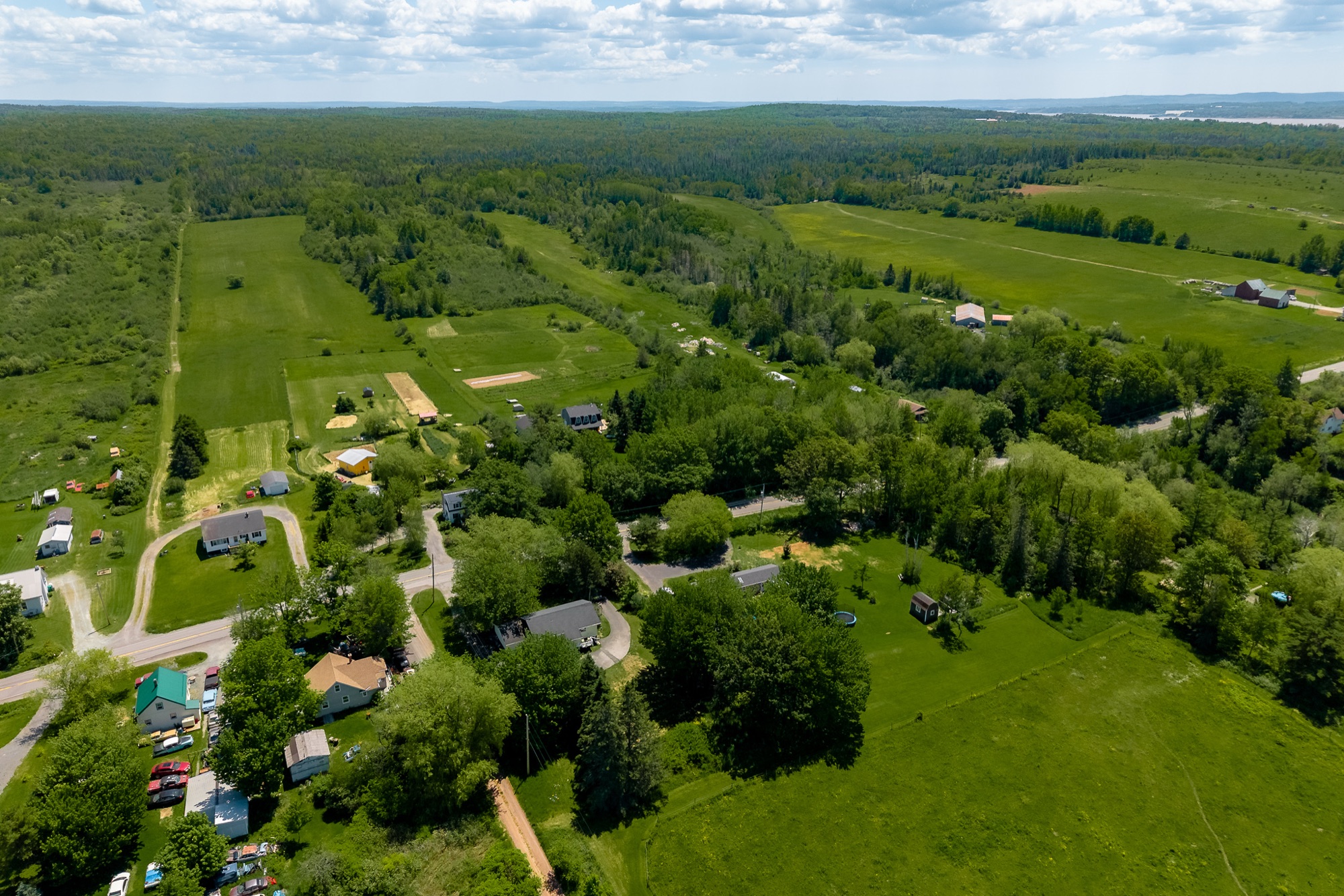 Aerial of green farmland rolling down to the Minas Basin