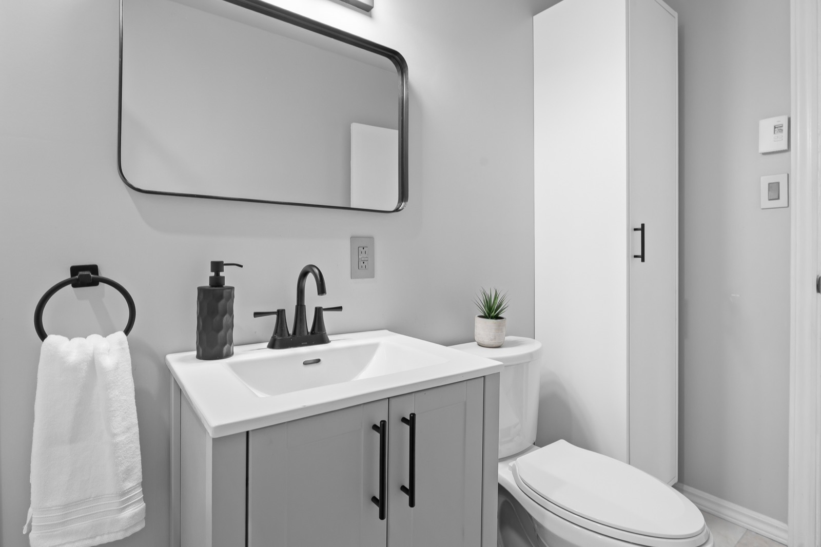 Bathroom vanity with framed mirror and linen storage