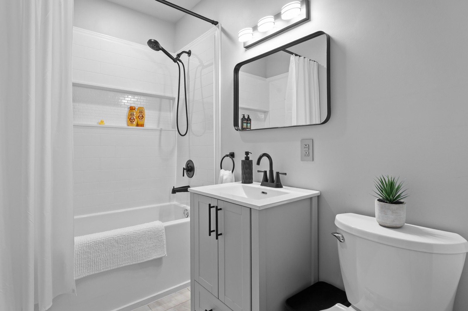 Renovated bathroom with white subway tile and black fixtures