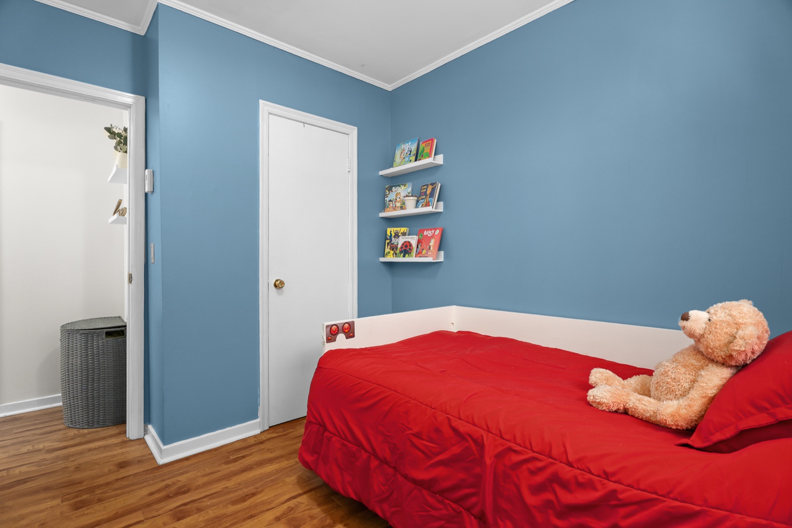Bedroom 2 — blue room with the red bed, book ledges, and teddy