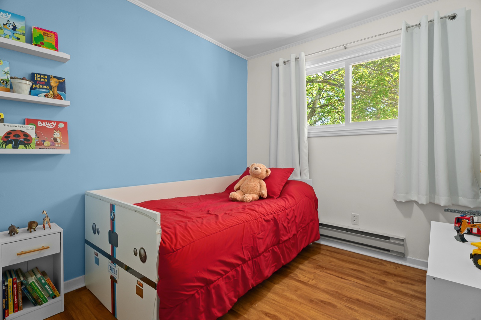Bedroom with bright blue walls and a red duvet