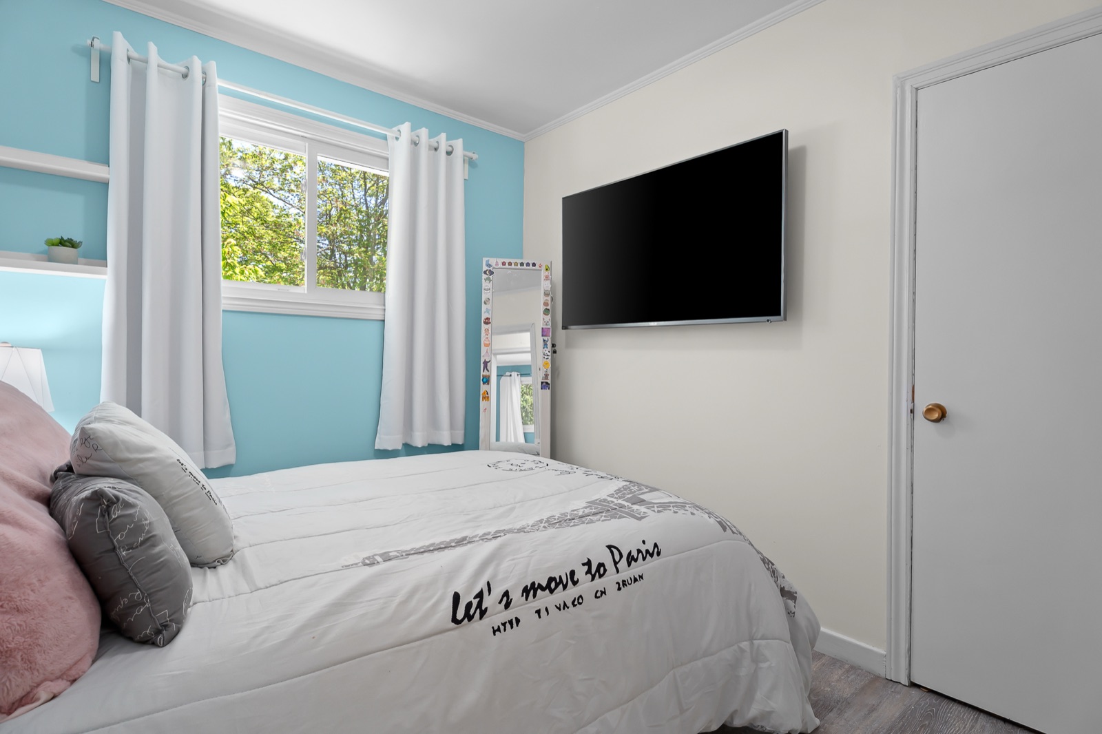 Bedroom 3 — the blue Paris-themed room with bed, window, and TV