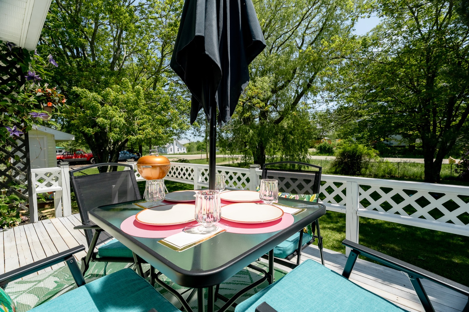The front-deck dining table set beneath the umbrella