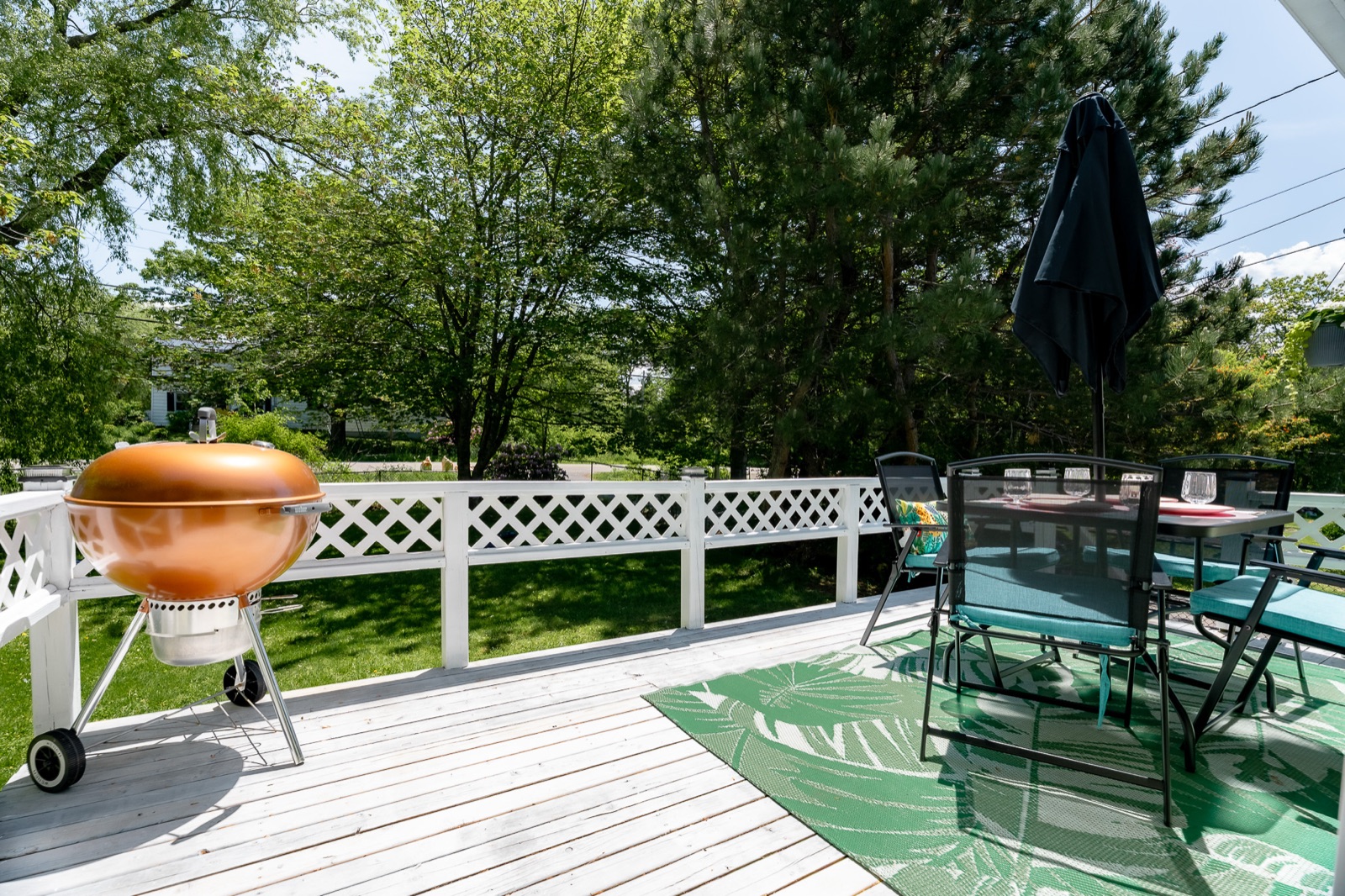 Front deck with patio table, umbrella, and barbecue