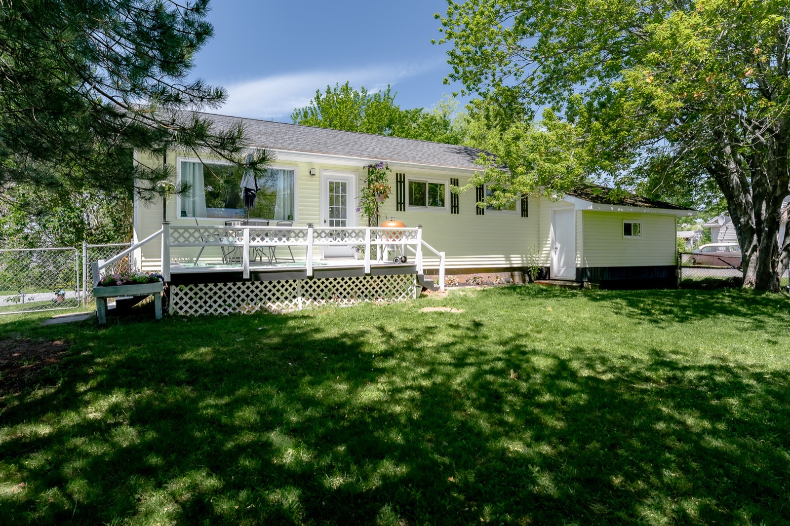 The home and white deck seen from the side lawn