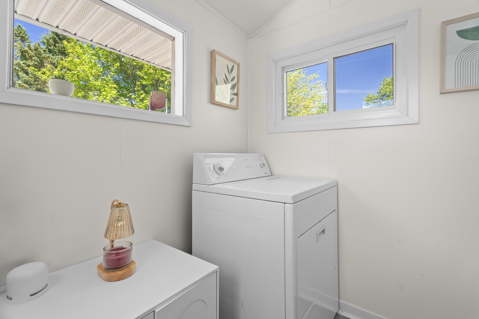 Bright laundry room with washer and windows