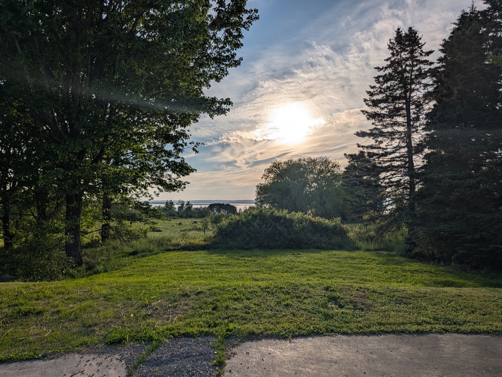 Golden-hour view across the yard to the water